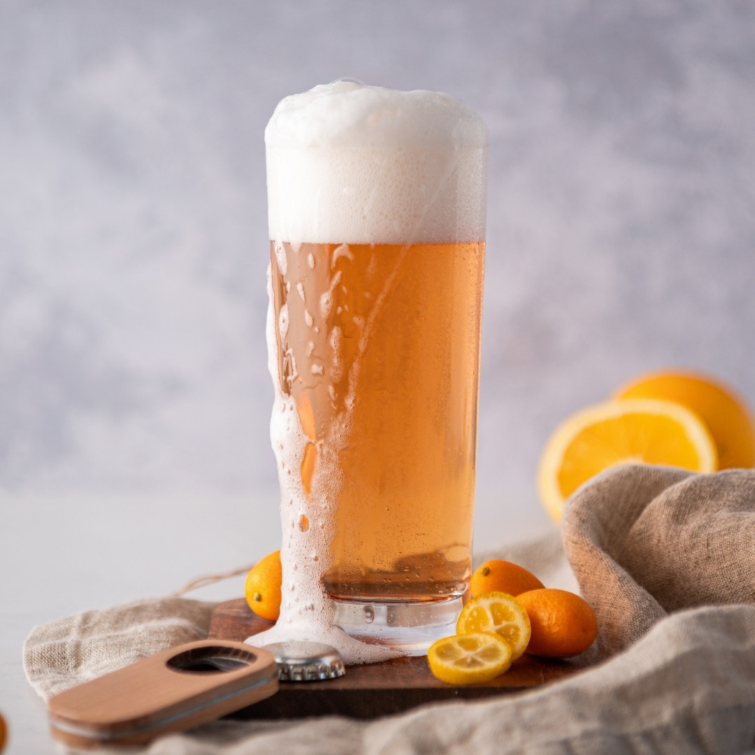 Beer in a tall glass with kumquats