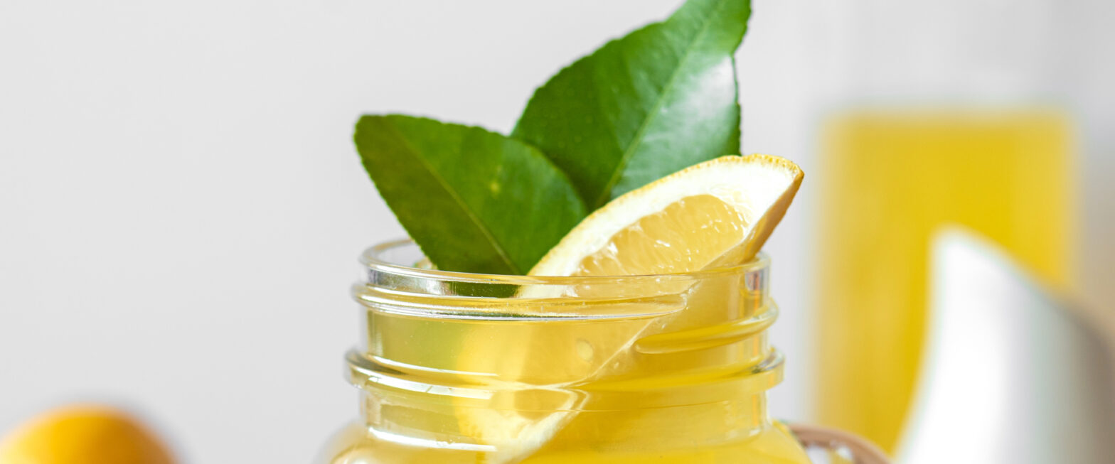Yellow beverage with lime and leaves