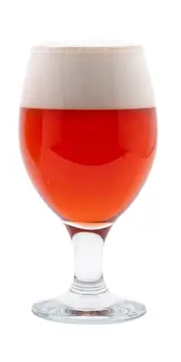 A glass of red colored beer